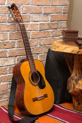 Accoustic guitar by the brick wall