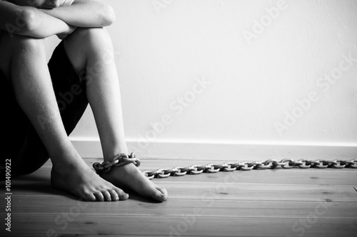 Fotomural Abused Boy with Chain on his Foot in Monochrome