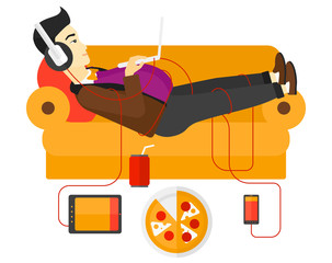 Wall Mural - Man with gadgets lying on sofa.