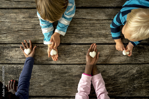 Fotografía Vista superior de cuatro niños de razas mixtas cada uno con una canica h