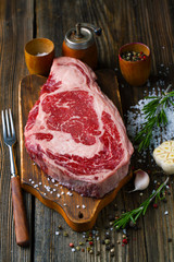 Canvas Print - Raw ribeye steak marbled meat with salt, rosemary and garlic