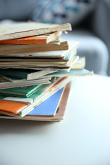 Poster - Pile of old books on white table in the room. Focus on books and blurred background