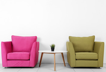 Wall Mural - Living room interior with pink, green armchairs, white table and plant on white wall background