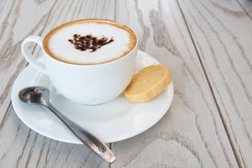 Wall Mural -  cappuccino coffee cup on wood table at coffee shop