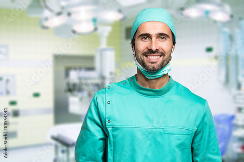 Fotomural Smiling surgeon crossing his arms while standing in a surgical room