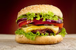 Big cheeseburger isolated on red background