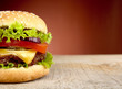 Big cheeseburger cropped on red background