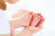 © JenkoAtaman - feet newborn baby in arms him mother