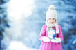 Little girl with flashlight and candle in winter day outdoors