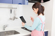 © miya227 - タブレットを見ながら料理をする女性