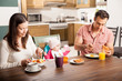 Parents and baby having breakfast at home