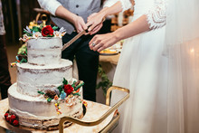 Bride And Groom Cut Rustic Wedding Cake On Wedding Banquet With