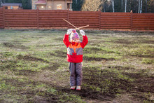 Little Girl Gives Signals With Wooden Sticks