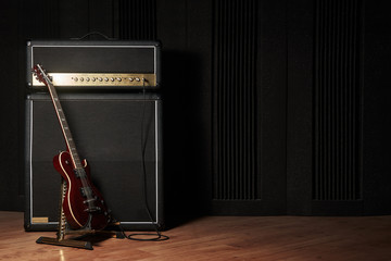 Red electric guitar and classic amplifier on a dark background