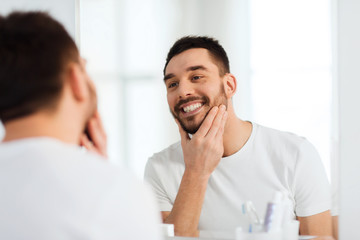 Poster - happy young man looking to mirror at home bathroom