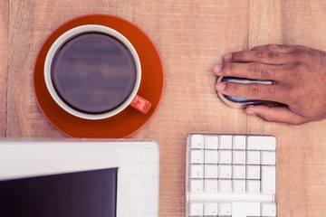 Poster - Cropped hand of businessman using mouse while working at table 