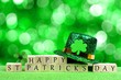 Happy St Patricks Day wooden blocks with leprechaun hat and shamrock over twinkling green background