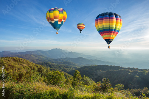 Fotografía Globo de aire caliente por encima de alta montaña al atardecer