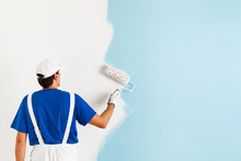 Painter Painting A Wall With Paint Roller
