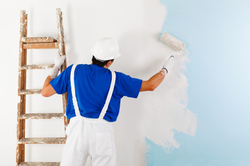 Wall Mural - painter painting a wall with paint roller