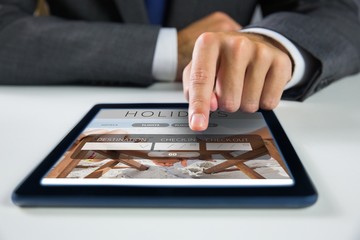 Poster - Composite image of businessman using digital tablet