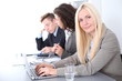 © rogerphoto - A group of business people at a meeting on the background of office. Focus on a beautiful blonde