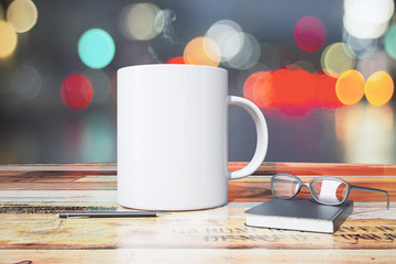 White cup with pen, diary and eyeglasses on wooden table