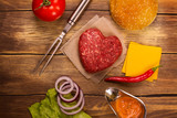 Fototapeta Zwierzęta - Burger ingredients over rustic wooden table. Top view