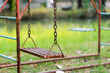 Old rusty playground swing in the park