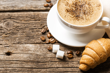 Wall Mural - Close-up of coffee cup with roasted coffee beans on wooden backg