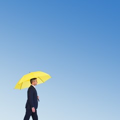 Poster - Composite image of businessman with yellow umbrella walking 