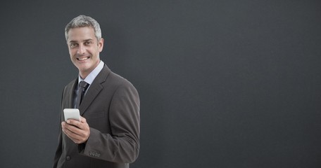 Wall Mural - Portrait of smiling businessman holding smartphone