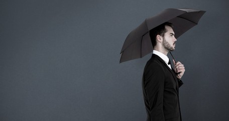 Poster - Composite image of businessman under umbrella on black screen