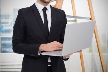 Poster - Composite image of mid section of a businessman using laptop