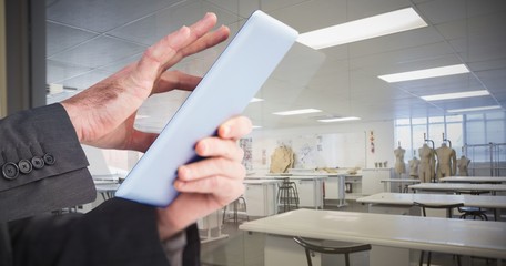 Poster - Composite image of businessman scrolling on his digital tablet