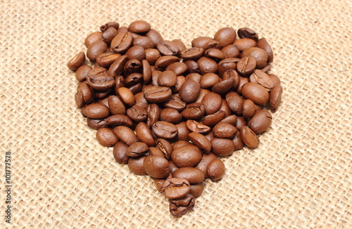 Fototapeta dla dzieci Heart shaped coffee beans on jute background