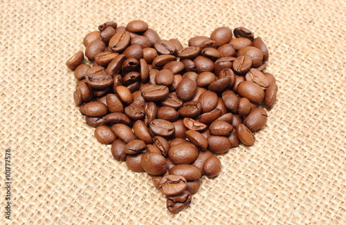 Naklejka na szybę Heart shaped coffee beans on jute background