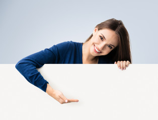 Brunette woman in casual clothing showing blank signboard