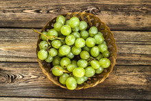 Bunch Of Green Grapes In The Basket On Wooden Planks