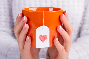 Fotomurales - Beautiful orange cup with love tea bag.