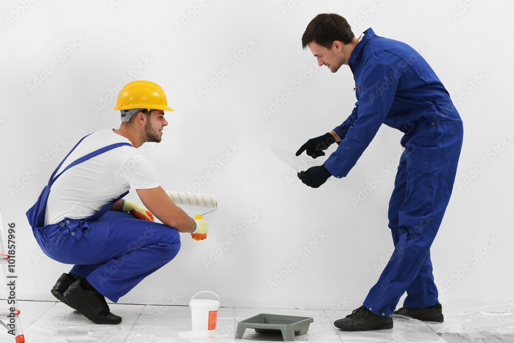 Workers renewing apartment on wall background
