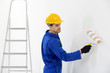 © Africa Studio - Worker renewing apartment on wall background