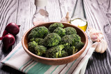 Fototapeta Mapy - Bunch of fresh green broccoli on brown plate over wooden background