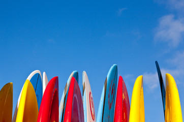 stack of surfboards with sand on surface