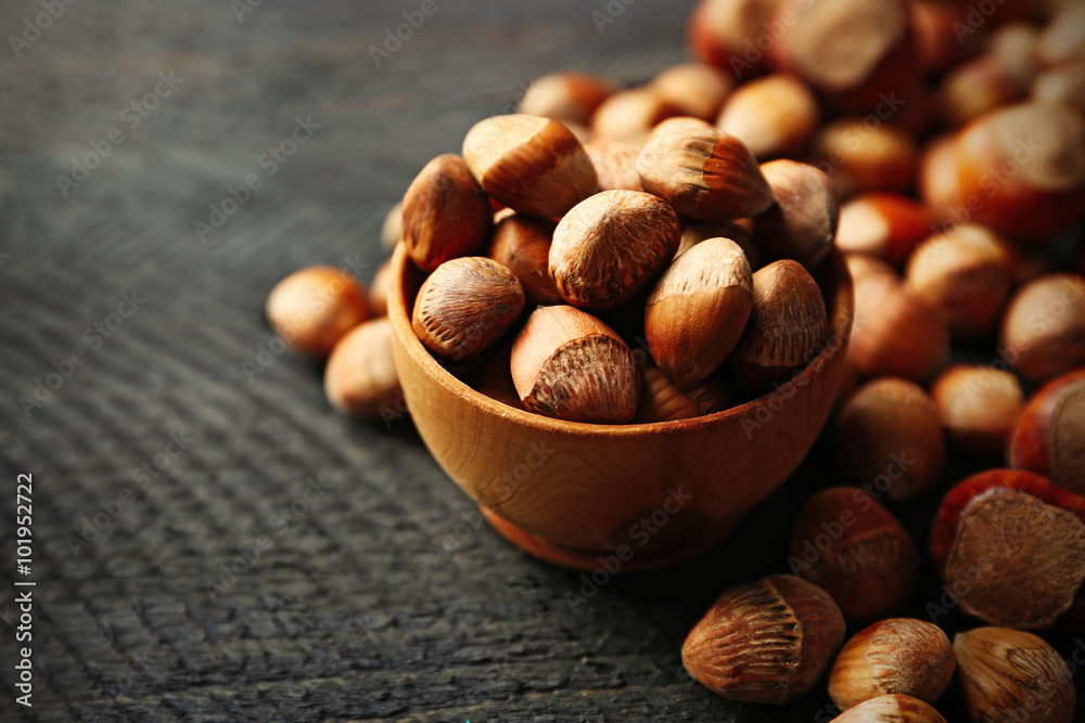 Scattered hazelnuts and acorns on grey wooden table