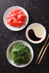 Wall Mural - Wakame seaweed salad with sesame seeds on a table. vertical top view
