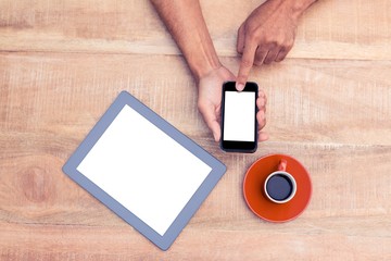 Poster - Person using smart phone by coffee and tablet on table