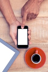 Poster - Person using smart phone by coffee and tablet on table