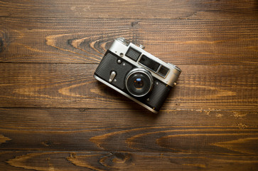 manual camera lying on old wooden background