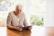 Focused senior woman using tablet